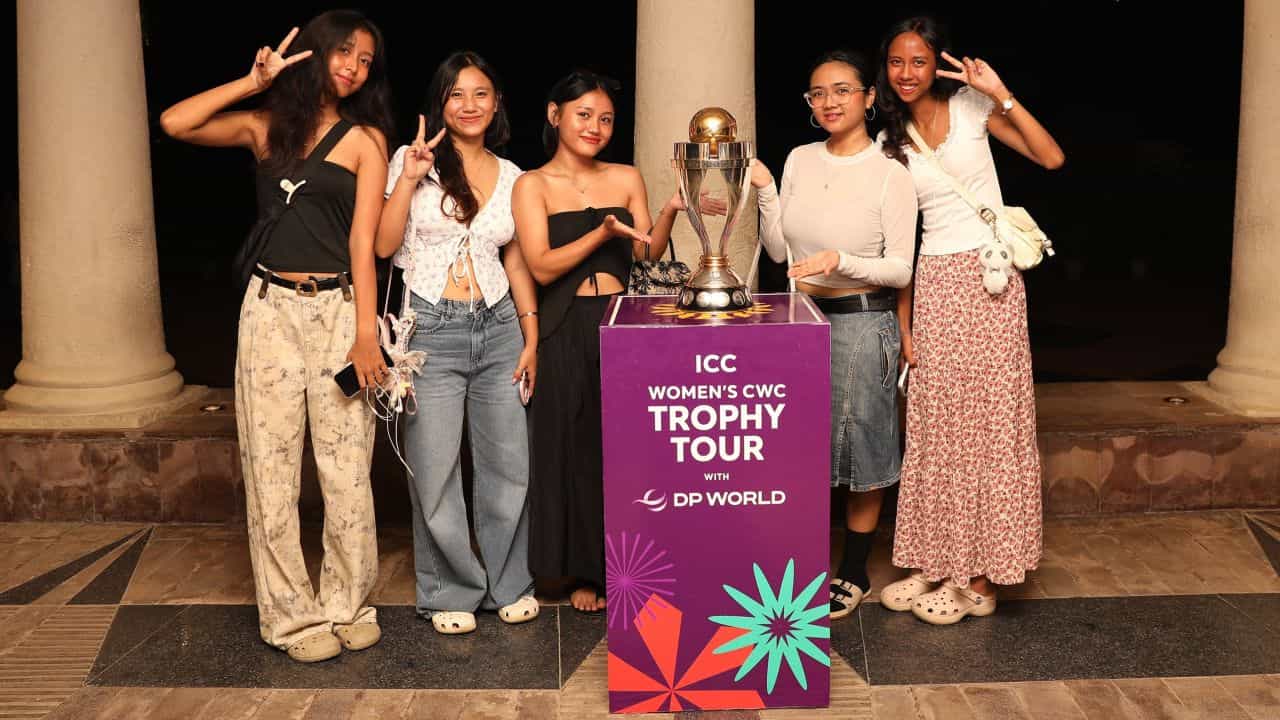 Fans pose with the ICC Women's Cricket World Cup 2025 Trophy